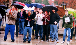 In 2004, a group of students gathered in the rain in front of Lee Hall to support the Living Wage campaign. Photo courtesy of UMW Libraries' Special Collections and University Archives/Battlefield Yearbook.