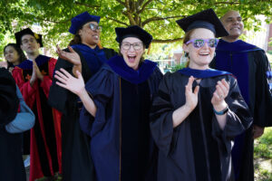 Faculty members line up on either side of Campus Walk to cheer on the graduates. Photo by Suzanne Carr Rossi.