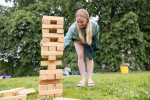 A student plays with a giant Jenga game at the University of Mary Washington's Devil-Goat Day. Photo by Parker Michels-Boyce.