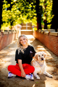 Senior and champion swimmer Kinsey Brooks, pictured with her pup Mozart, excelled at balancing her nursing program and swimming commitments, earning numerous accolades and securing a position in a top-ranked neonatal intensive care program.