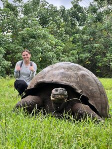 Brunt received the Sally Brannan Hurt '92 Study Abroad Scholarship in Biology, which gave her the opportunity to travel to the Galápagos Islands to study the flora and fauna of one of the most biodiverse places on the planet. Here, she poses for a photo with a Galápagos tortoise at an ecological reserve, El Chato Ranch, on the island of Isabela. Photo courtesy of Madeline Brunt.