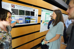 Professor of Earth and Environmental Science Pamela Grothe looks on as UMW student Kate Stoneman presents 'Why is Shark Tooth Island Disappearing?' during Research and Creativity Day. The project, completed along with faculty mentor John Tippett, investigates the affects of climate change on the island. Photo by Suzanne Carr Rossi.