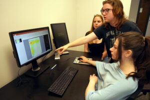 From left to right, UMW psychology majors Kelly Simons, Tobias Conner and Julia Patrick process the results of their Arts, Humanities and Social Sciences Summer Institute project. Their research tracked eye movements during test-taking. Photo by Suzanne Carr Rossi.