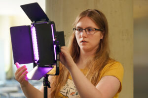 UMW senior Katie Reif adjusts lighting during a five-week session on filmmaking that was part of UMW's Arts, Humanities and Social Sciences Summer Institute. Photo by Suzanne Carr Rossi.