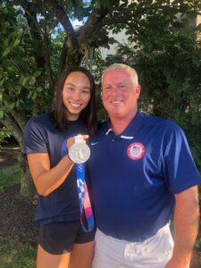 Torri Huske poses with her coach, Mary Washington alumnus Evan Stiles '91 after winning silver in Tokyo in 2021. This year, she captured three gold medals and two silvers.