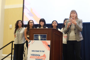 Center for Community Engagement Director Sarah Dewees kicks off the Virginia Student Voting Summit in UMW's Chandler Ballroom. With her onstage are members of UMW Votes (from left to right), Chiara Baez, Alexandra Schwartz, Melanie Billescas and Sarah Tyree-Herrmann. Photo by Karen Pearlman.