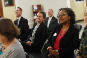 UMW Registrar Rita Dunston (foreground) looks on as the agreement is signed. Provosts, deans and other administrators attended the ceremony held in the Dodd Auditorium foyer in UMW’s George Washington Hall. Photo by Karen Pearlman.