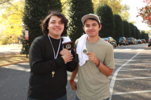 UMW first-year student Noah Rojas (left) and sophomore Kaiden Rojas carry stickers from their first time voting. The brothers joined nearly 300 UMW students who took advantage of a trolley ride to the Fredericksburg polls, made possible by a Fund for Mary Washington Impact Grant, during UMW's Day on Democracy. Photo by Karen Pearlman.