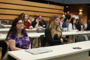 UMW business students Alexandria Menzies (left) and Avery Bonner, who were first to share their presentation during the College of Business Case Competition, listen as other teams take their turns. Photo by Karen Pearlman.