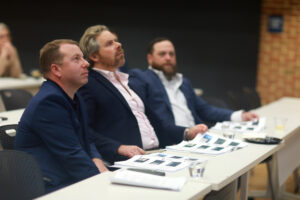 Judges (from left to right) Andrew Blate '04, Travis Bjorklund '02 and Craig Schneibolk listen to presentations by business students during the College of Business Case Competition. Blate and Schneibolk, who own Beautiful Home Solutions, created the endowed fund that covers the competition's annual award money. Winners of the fall 2024 competition took home a total of $4,000 between them. Photo by Karen Pearlman.