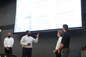 From left to right: Sudhanshu Sarin, Dwayne Clarke, Cole Hudak and Jeremy Sanchez share their winning presentation with the judges and audience members during the College of Business Case Competition. Photo by Karen Pearlman.