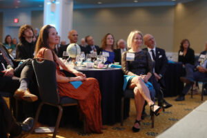 President Troy Paino and wife Kelly (right), who were the evening’s hosts, and other guests listen to UMW student speakers talk about their international education experiences at Mary Washington. Photo by Karen Pearlman.