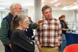 Director of Digital Learning Support Jerry Slezak (right) speaks with attendees Jane and Paul Berge at the 'A Decade of Digital Convergence' exhibit opening. Celebrating the Hurley Convergence Center's 10-year anniversary, the display will be on view in the Digital Gallery through the end of the fall semester. Photo by Suzanne Carr Rossi.