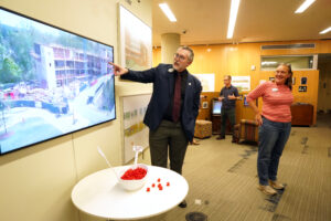 Chief of Staff and Vice President for Strategy Jeffrey McClurken and Associate Provost for Institutional Analysis and Effectiveness and Professor of Sociology Debra Schleef look at a time-lapse video of the construction of the Hurley Convergence Center. Opened 10 years ago, the building is a hub of connection, collaboration and creativity. Photo by Suzanne Carr Rossi.