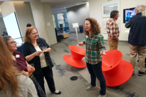 From right to left: Digital Knowledge Center Associate Director Shannon Hauser talks with Simpson Library Head of Special Collections and University Archives Emeritus Carolyn Parsons and Head of Special Collections and Digital Scholarship Angie Kemp. The nearly iconic red 'spin' chairs behind Hauser were brought down from outside the fourth-floor Digital Knowledge Center for the opening reception of the 'A Decade of Digital Convergence' exhibit. Photo by Suzanne Carr Rossi.