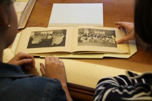 Seniors Candice Roland and Leah Tams look through 100-year-old Mary Washington yearbooks in the Simpson Library. Photo by Leigh Williams ’14